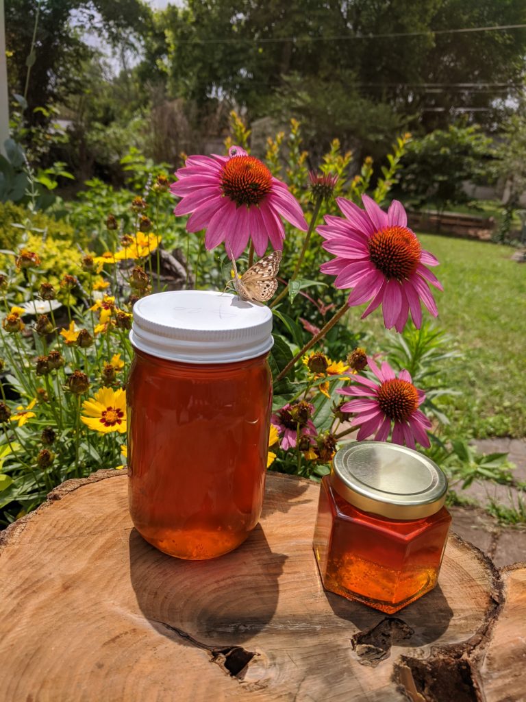 A Honey Hive's honey in the sun with flowers.